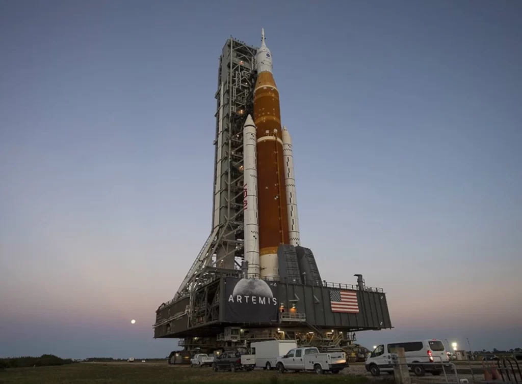 Il cingolato sta trasportando il razzo SLS e la navetta Orion per la missione Artemis I del programma Artemis: che porterà di nuovo gli astronauti sulla superficie della Luna.