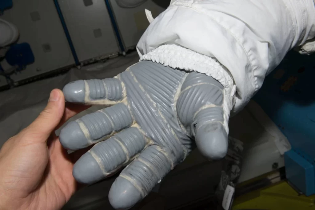 I guanti della tuta spaziale devono essere isolati contro le temperature estreme dello spazio esterno. Il finanziamento della NASA per esplorare i materiali a cambiamento di fase in questa applicazione ha portato a un materiale in tessuto che ora si trova in diversi prodotti.
