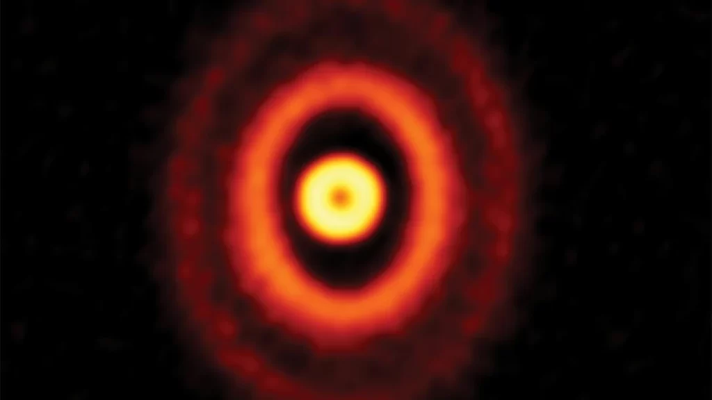 L’immagine mostra i 3 anelli del disco, dove quello interno ha forma circolare (visto dall’alto) mentre gli altri due sono osservati a un angolo tale da apparire ovali. Le tre stelle centrali non sono visibili.